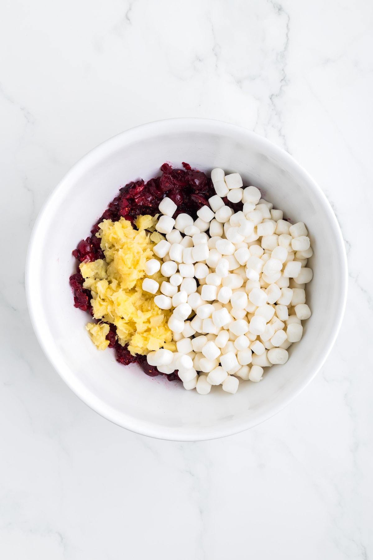 pineapple and cranberries in a bowl with marshmallows