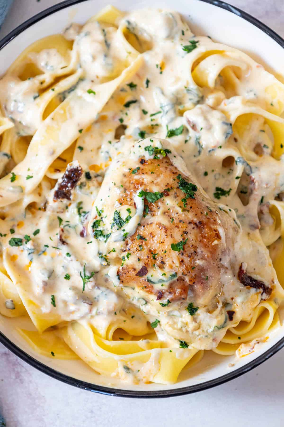 A creamy bowl of Tuscan pasta with chicken.