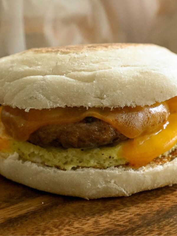 A breakfast sandwich with freezer egg muffins and cheese on a wooden table.