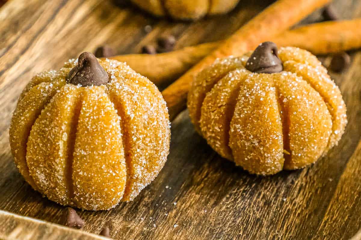 Pumpkin cheesecake truffles on a wooden tray.