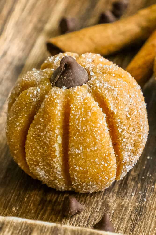 Pumpkin donuts with cinnamon and sugar on a wooden table.