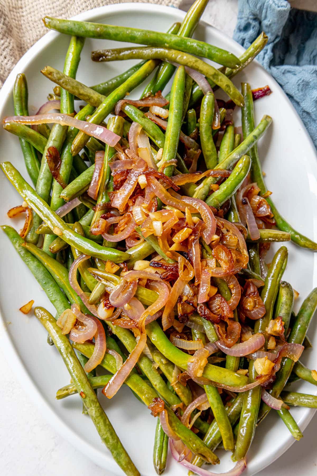 Sautéed green beans with red onion, served on a white plate.