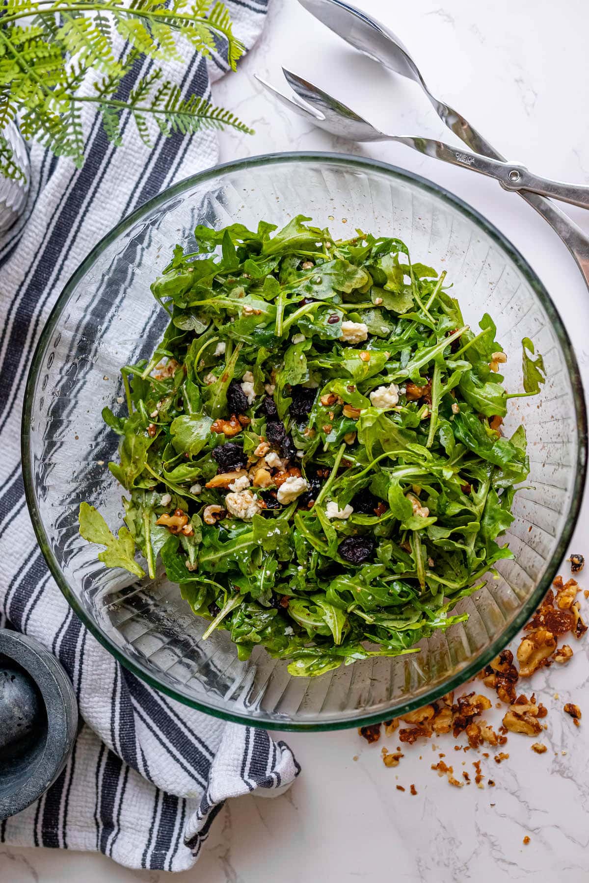 A salad featuring arugula, walnuts, and white cheese