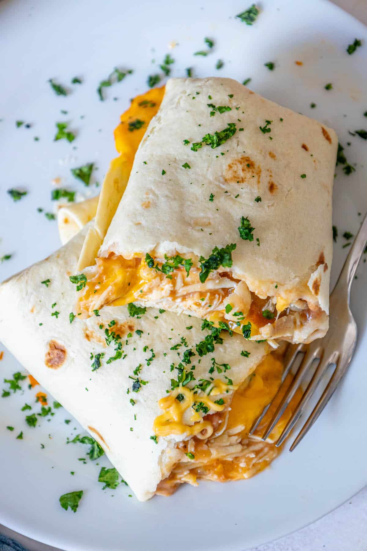 Baked chicken quesadillas on a white plate with a fork.