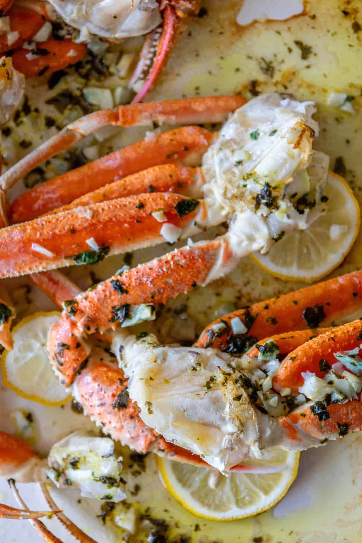 Baked crab legs with lemon wedges.