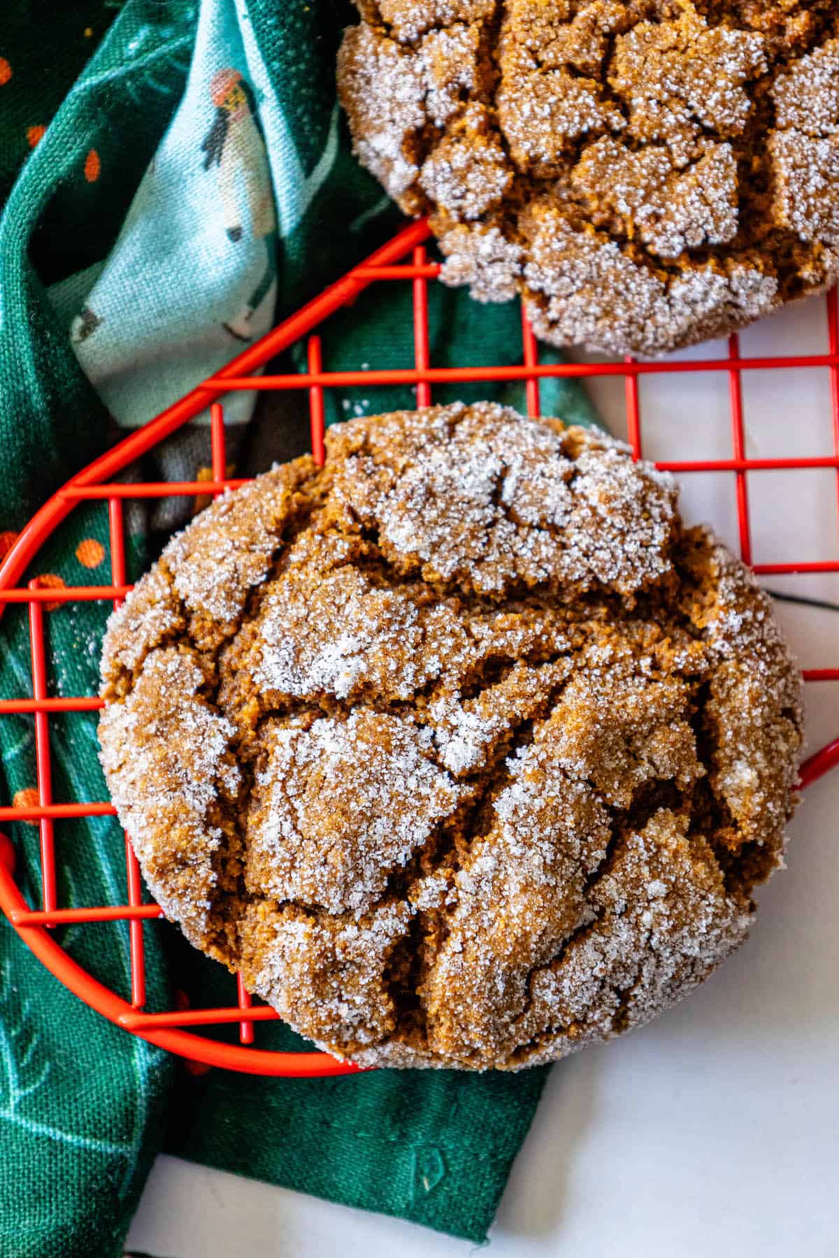 Keywords: soft gingersnap cookies recipe, molasses cookies
Description: Two molasses cookies cooling on a rack.