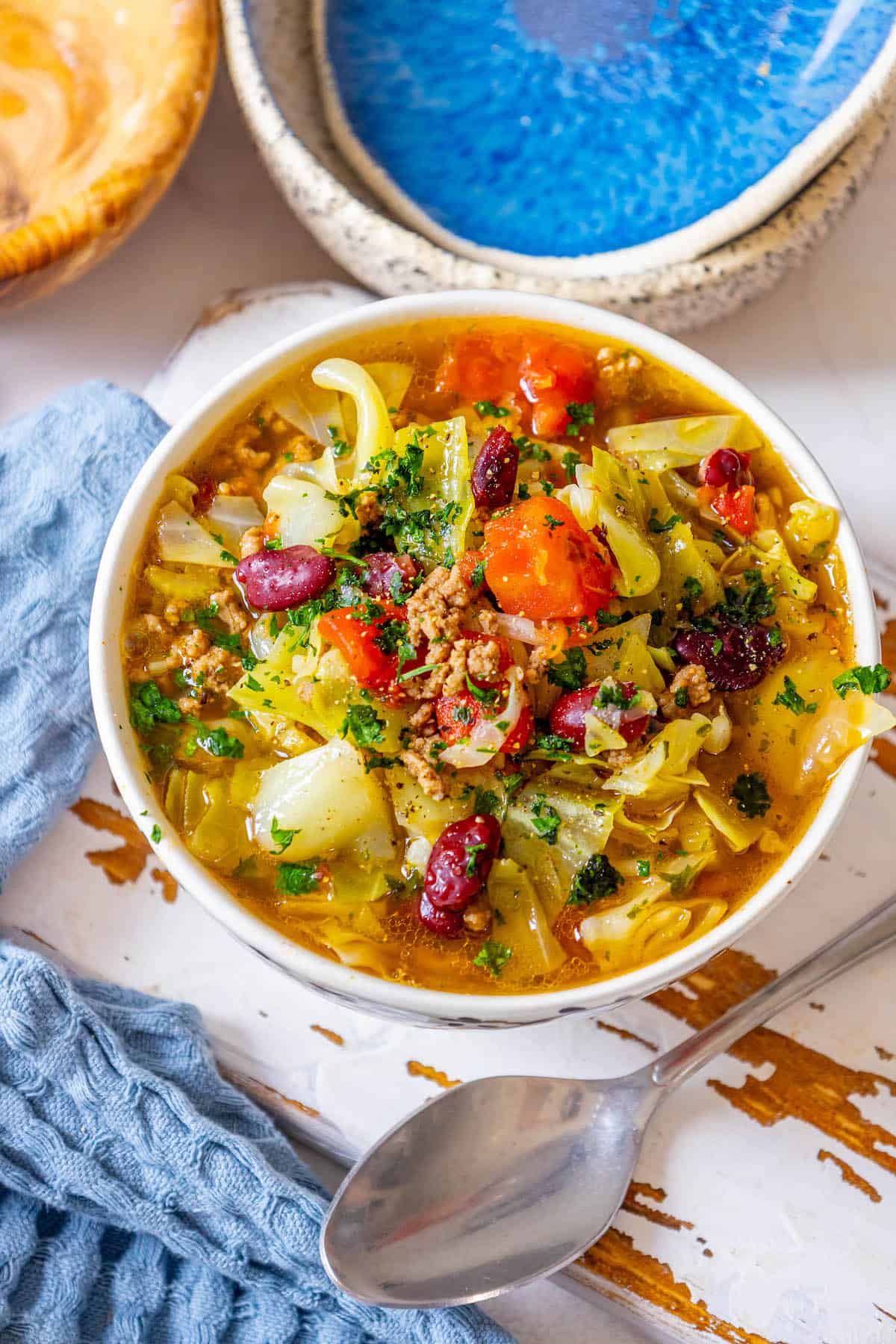 A bowl of soup with cabbage and meat.