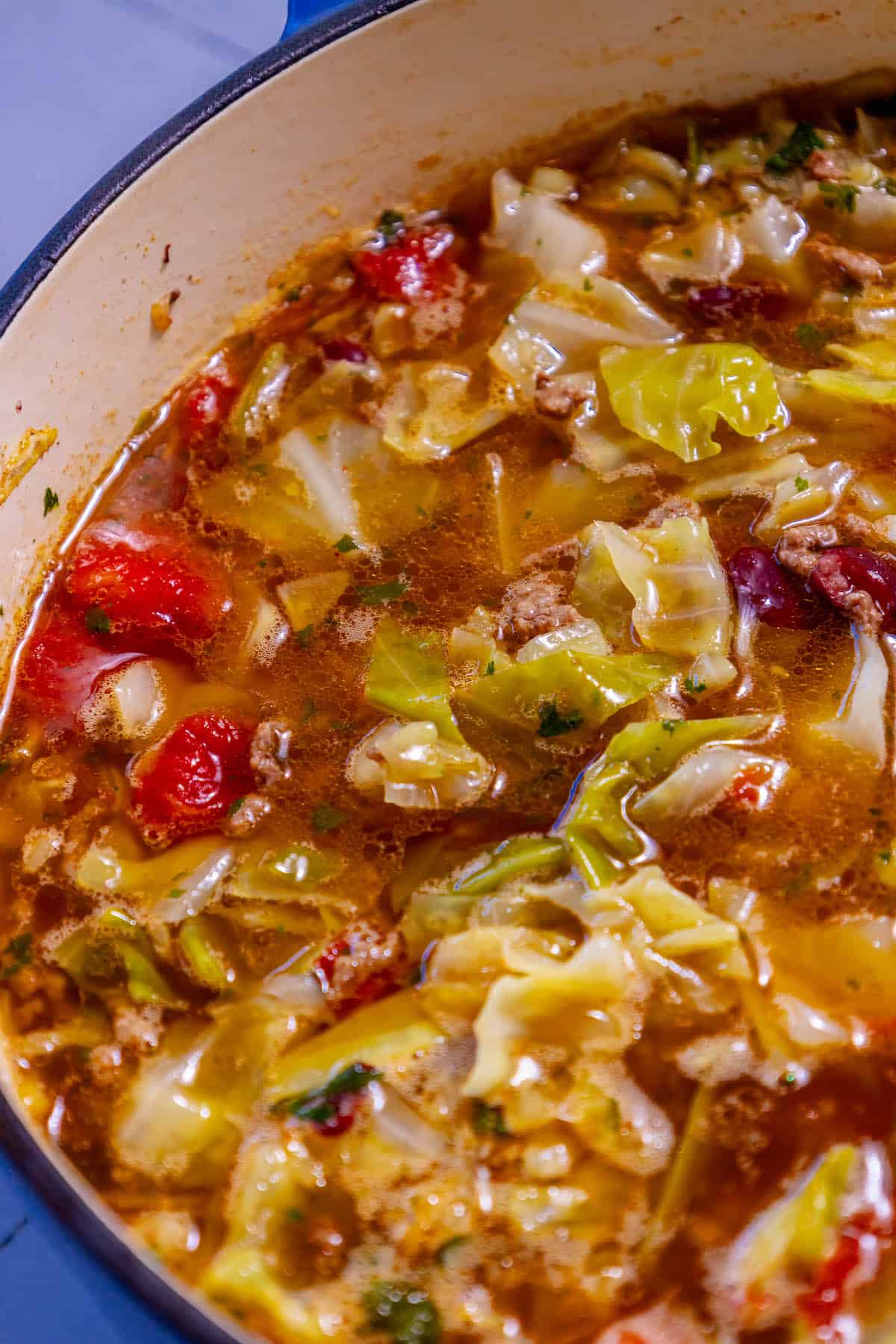 A pot of cabbage soup with meat and vegetables in it.