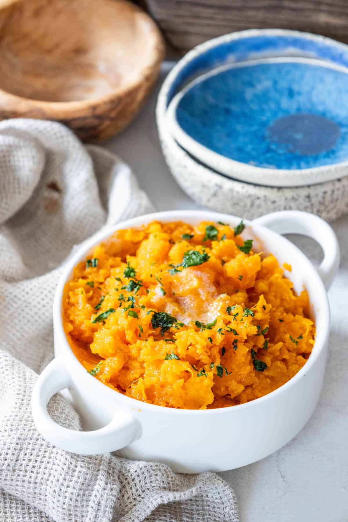 A bowl of mashed sweet potatoes on a table.