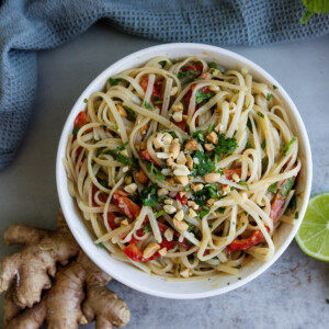 noodles, bell pepper, cilantro, and sauce, lime and ginger around them