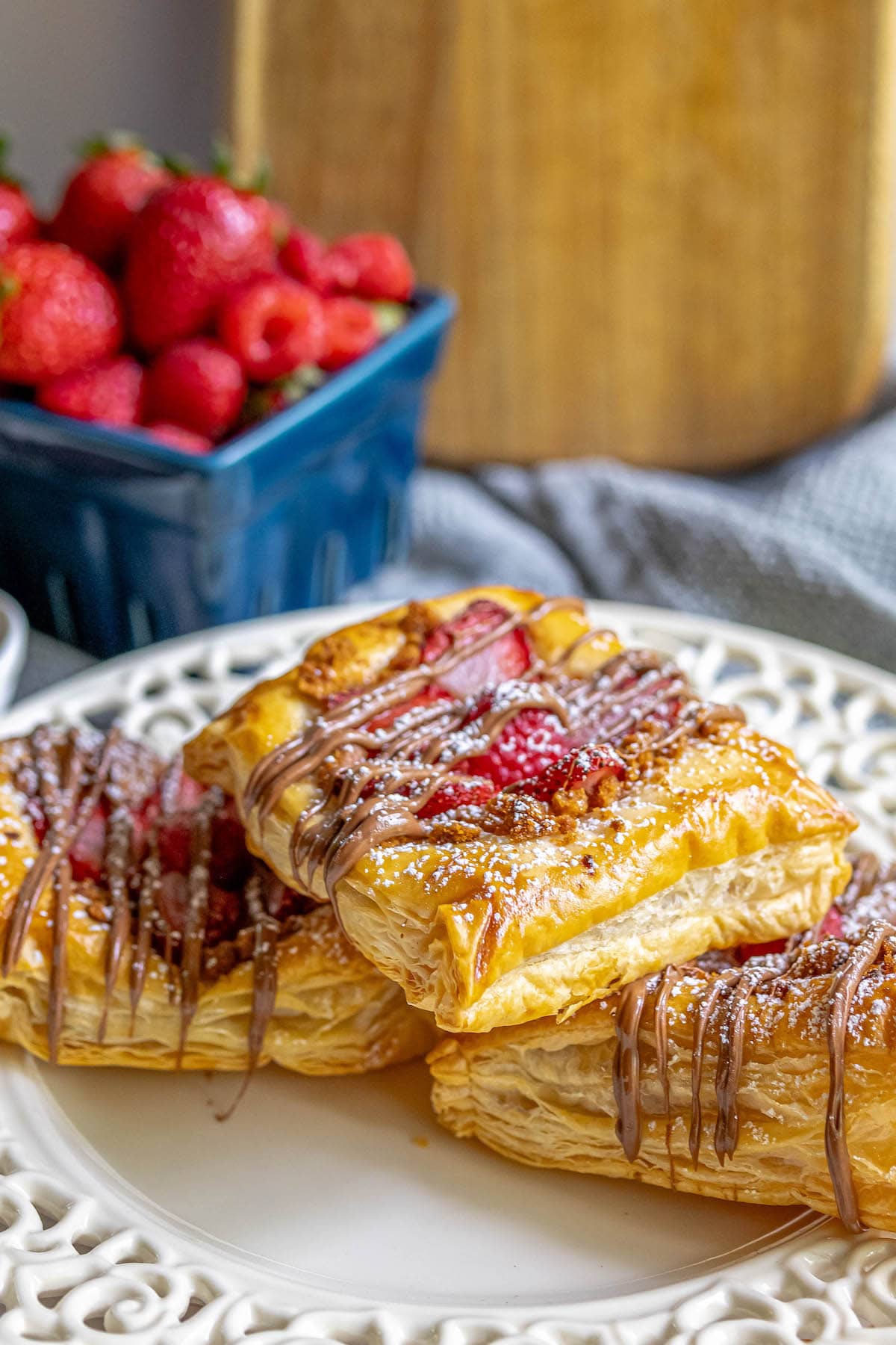 baked fruit tart on a table with berries and drizzled nutella on top