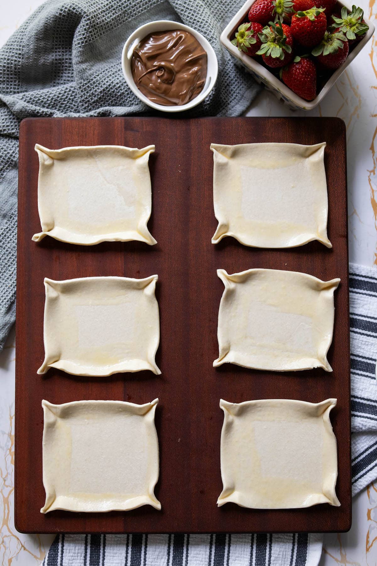 six pieces of puff pastry shaped like tarts