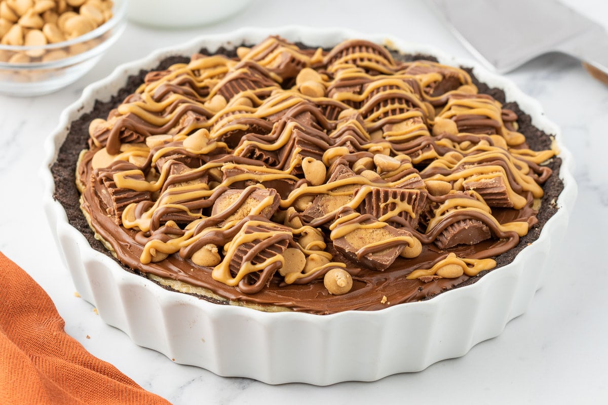 chocolate crusted pie with chocolate on top, peanut butter cups and butterscotch chips