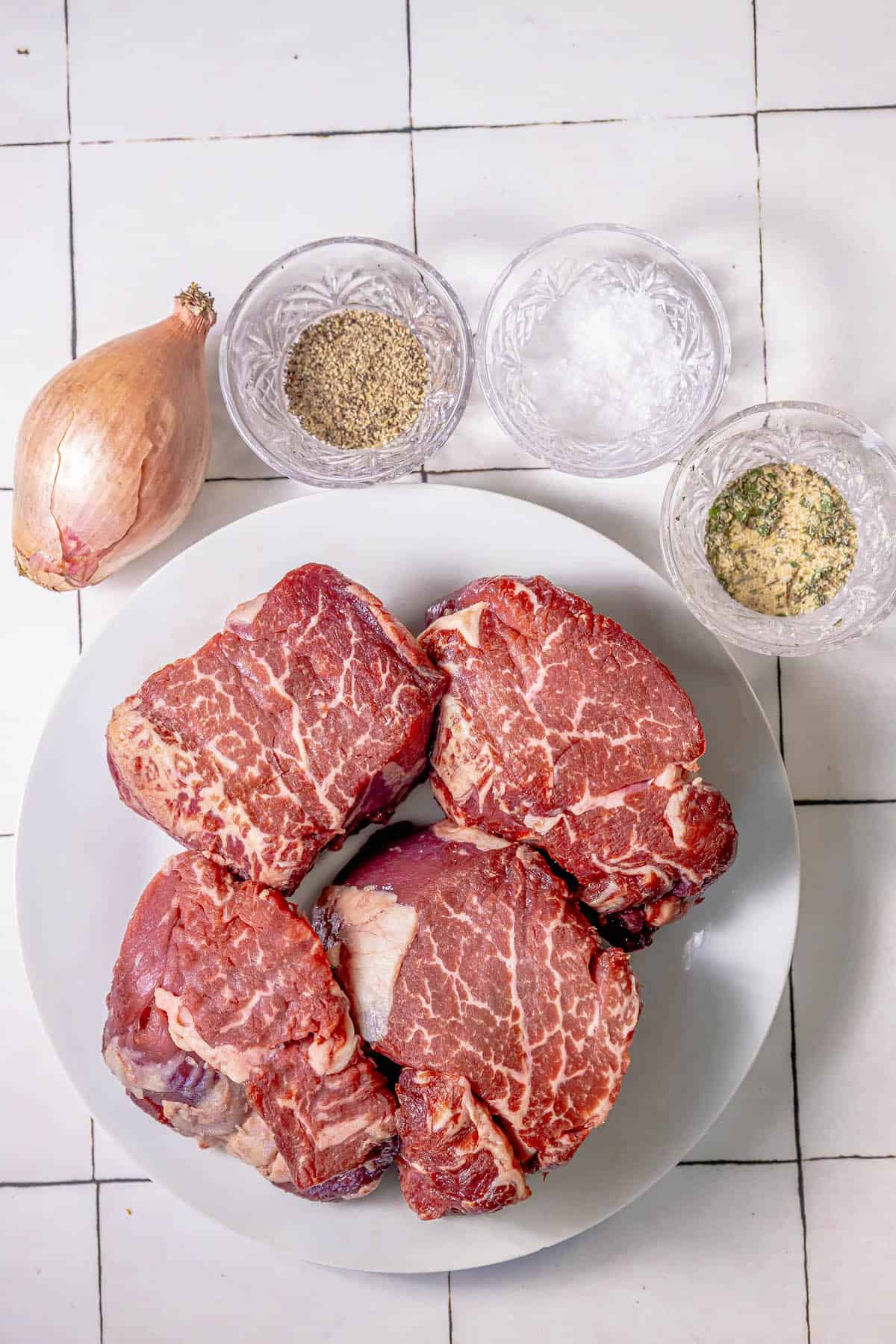 A plate of Reverse Sear Filet Mignon on a tiled floor.