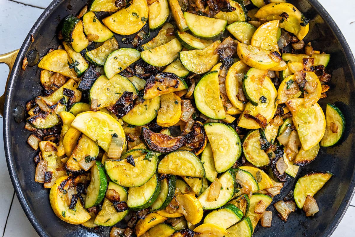 A keto recipe featuring pan-fried zucchini squash and mushrooms in a skillet.