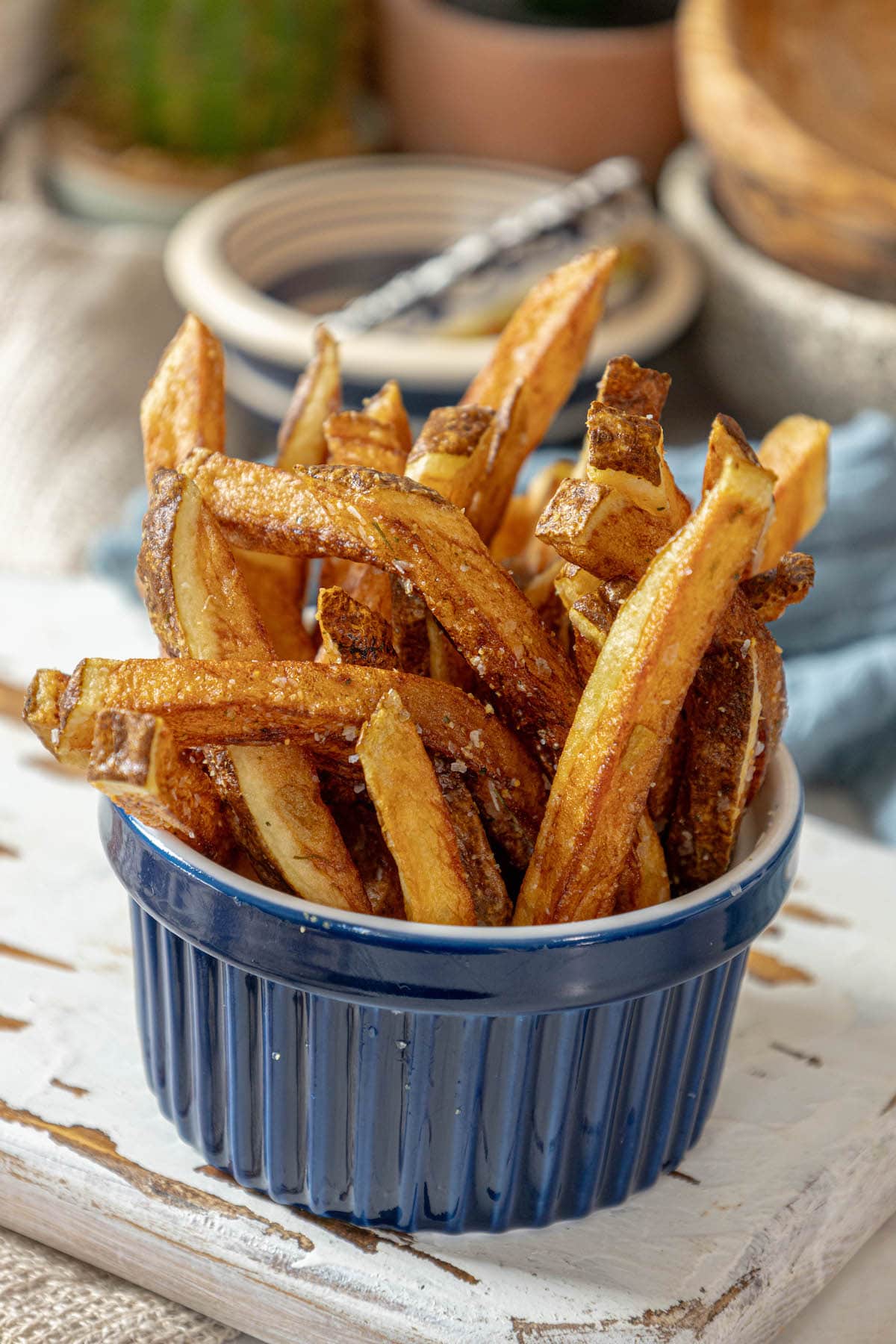 French fries in a blue bowl on a table.