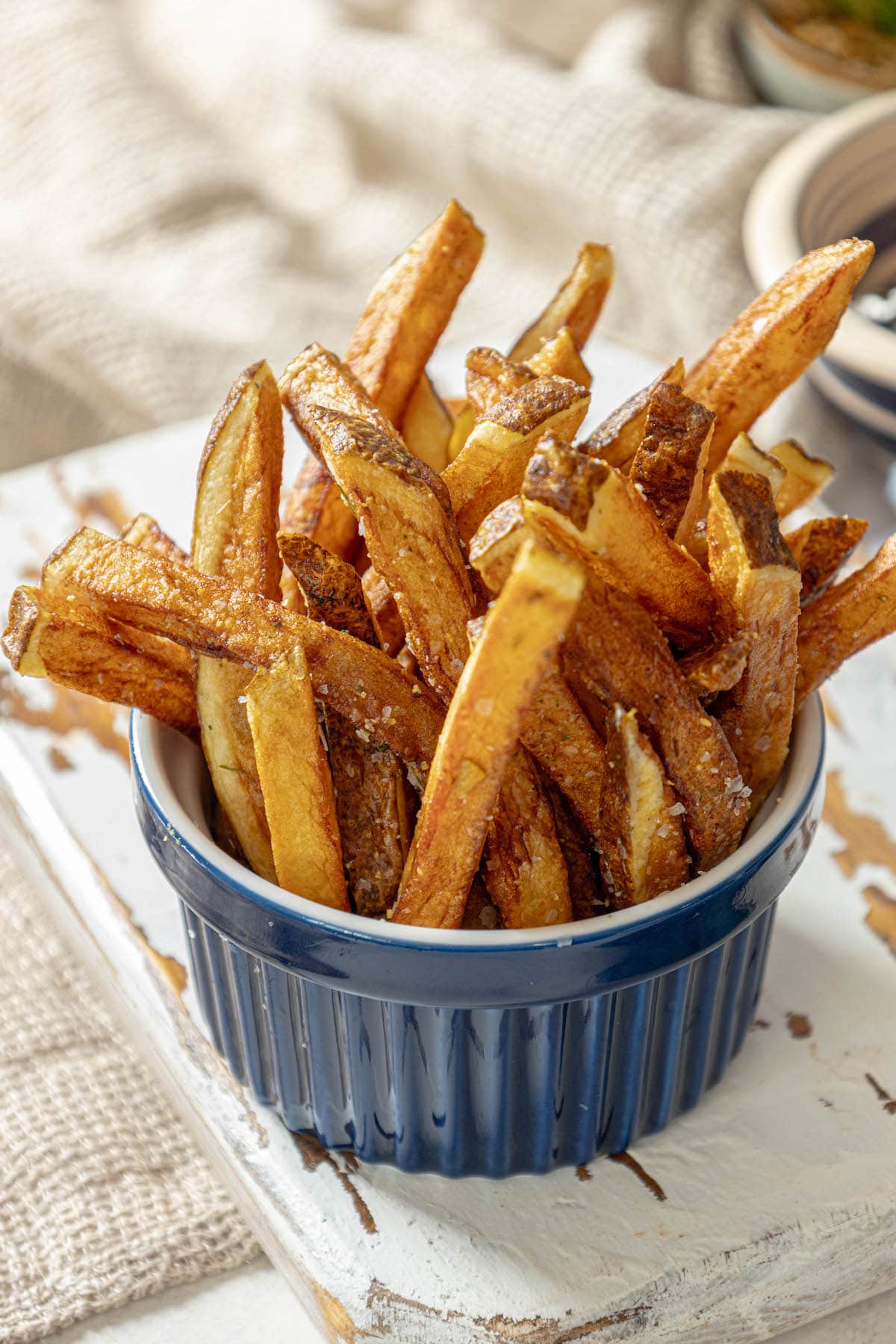 French fries in a blue bowl on a table.