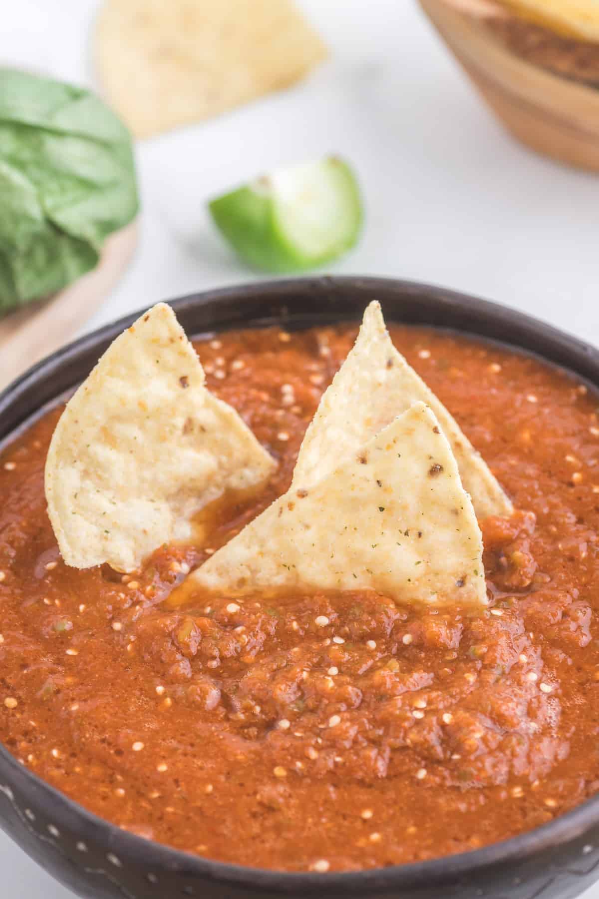 A bowl of Mexican salsa with tortilla chips, spiced with chipotle peppers.