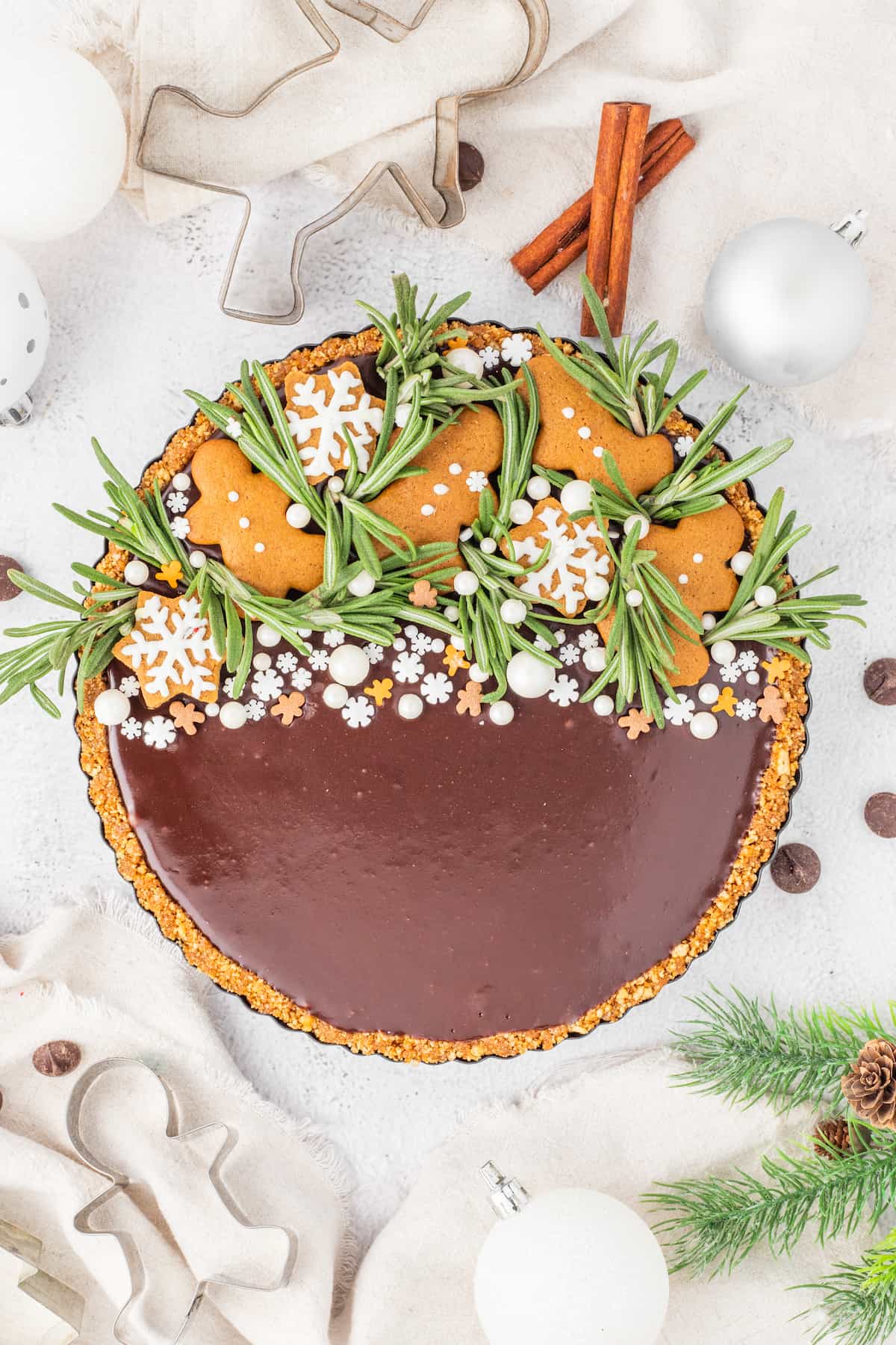 A gingerbread chocolate tart decorated with ornaments.