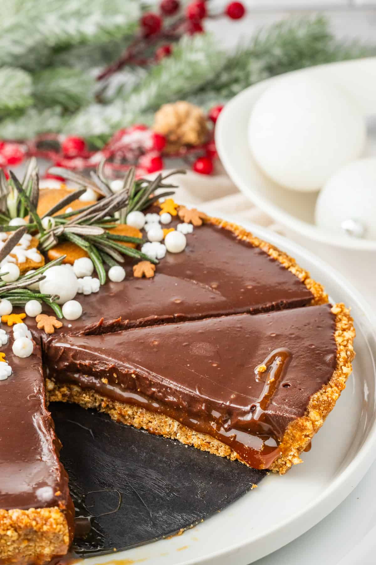 A Gingerbread Chocolate Tart with a slice taken out of it.