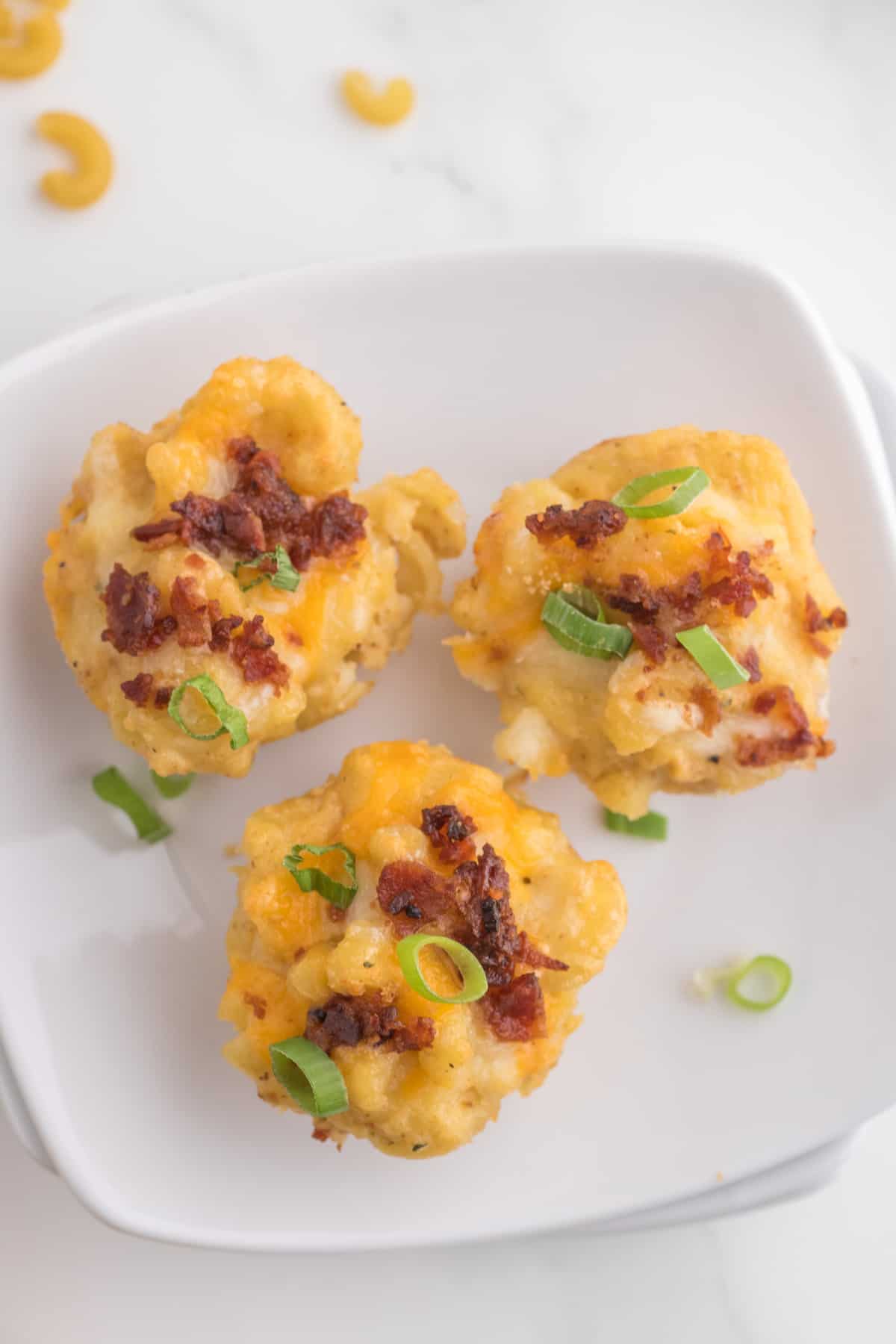 Cheesy mac and cheese bites on a white plate.