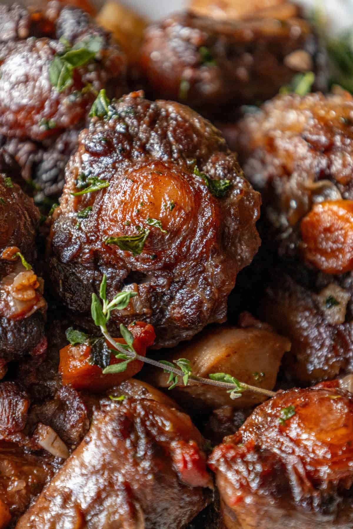 A plate of roasted oxtail stew with thyme.