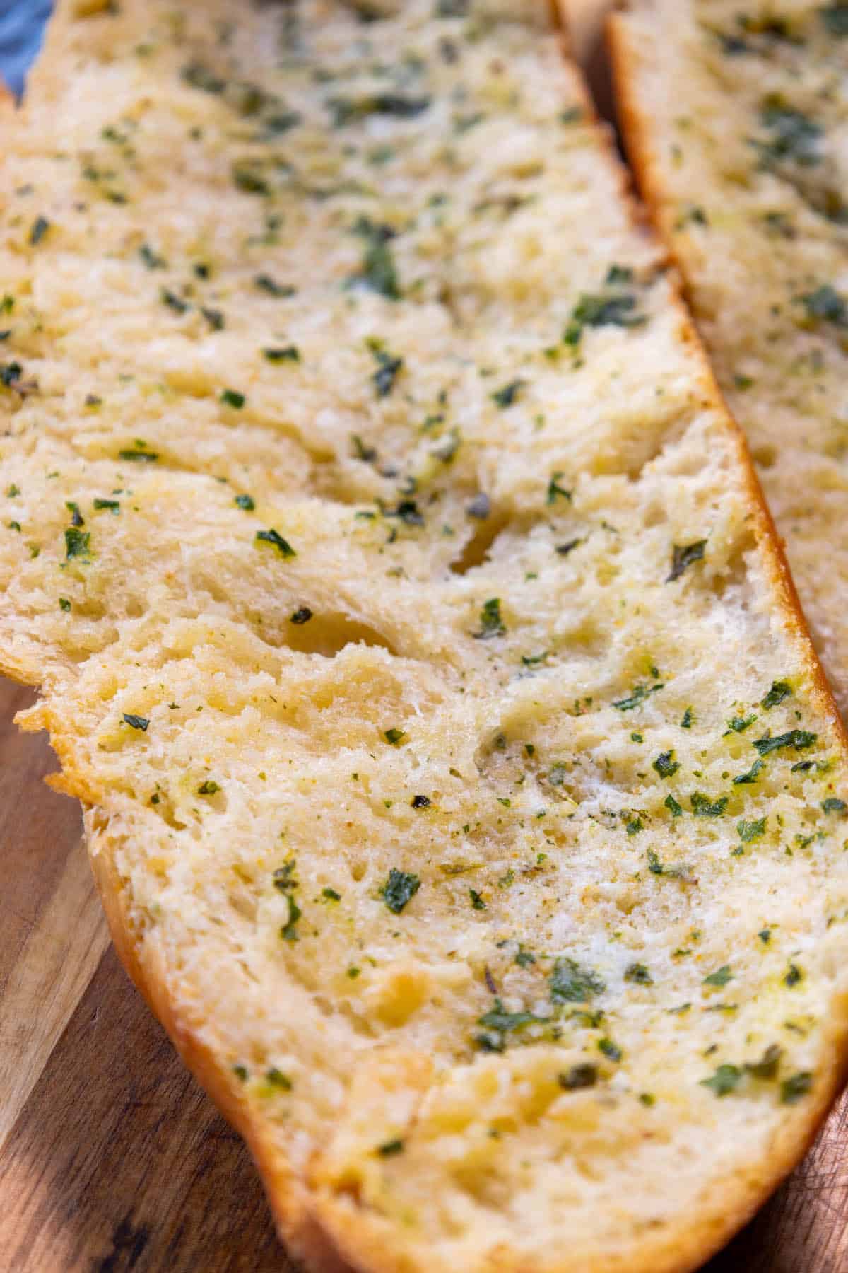 Two slices of garlic bread on a cutting board.