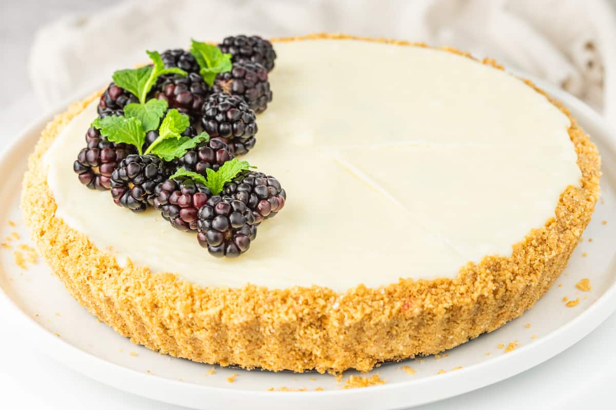A delicious white chocolate blackberry tart presented on a white plate.