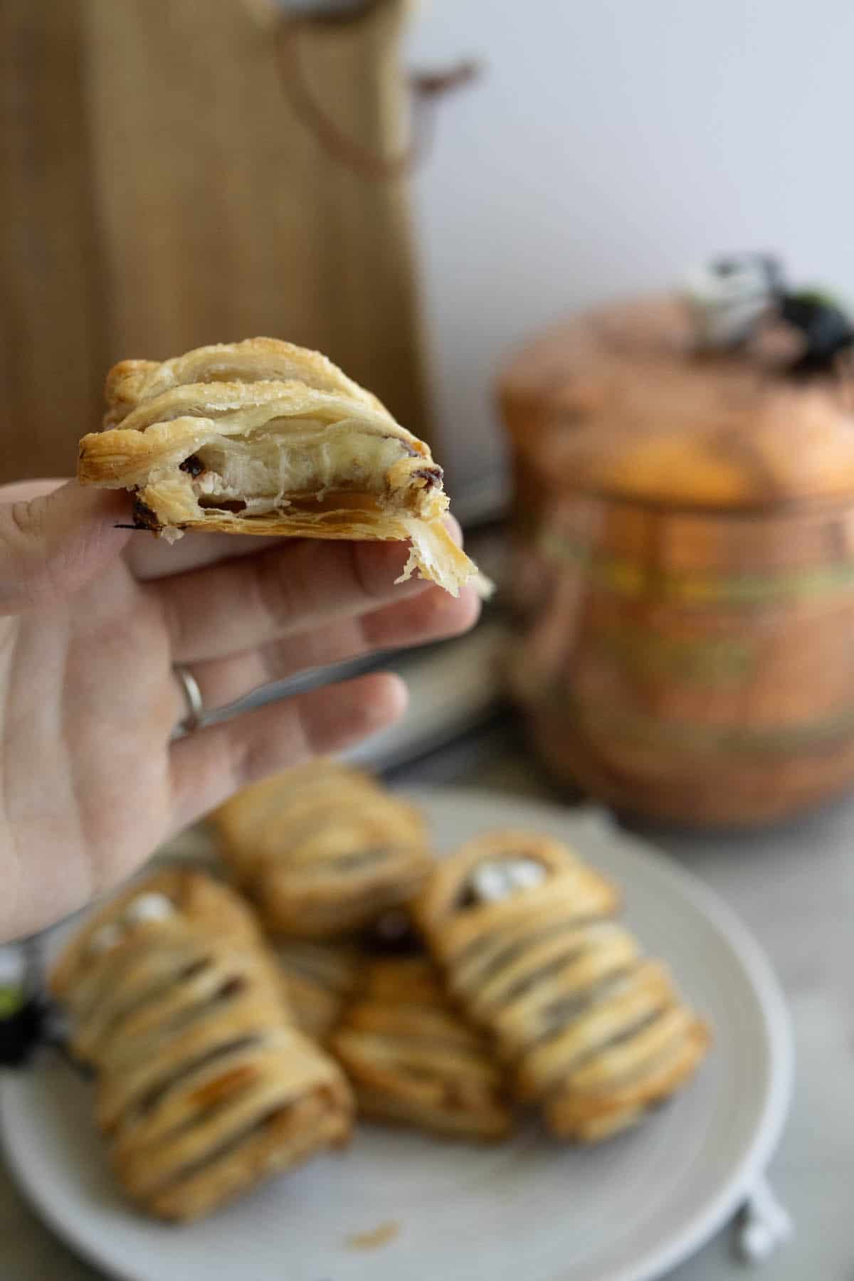 A person is holding a banana nutella pastry in front of a pot.