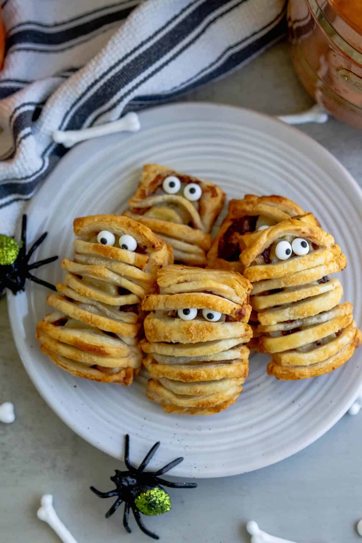 Banana Nutella mummies on a plate with pumpkins and spiders.