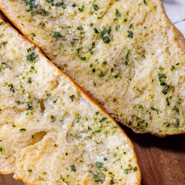 Two slices of easy garlic bread on a cutting board.