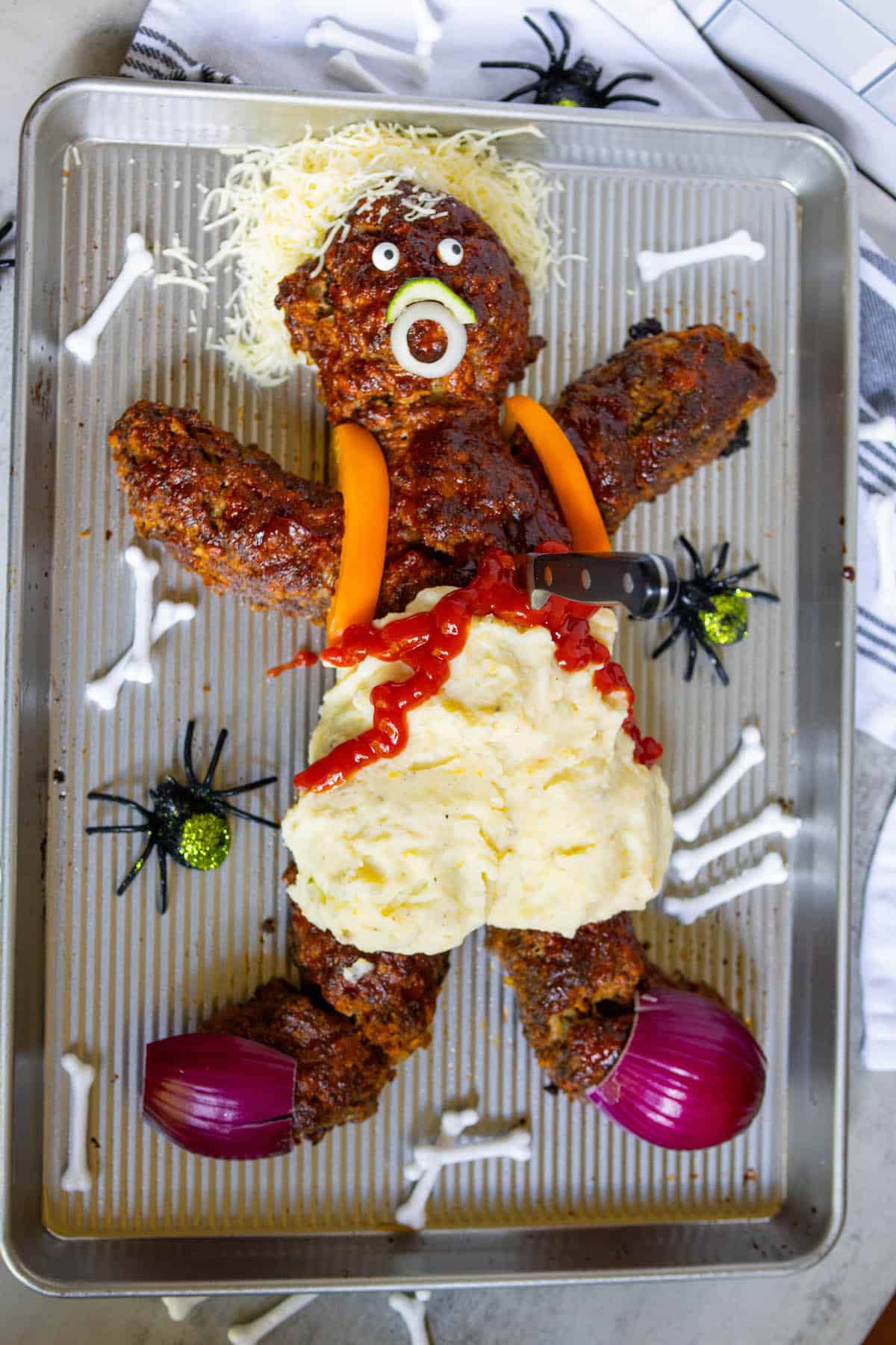 A metal baking sheet with a gory Halloween costume resembling a dead man meatloaf.