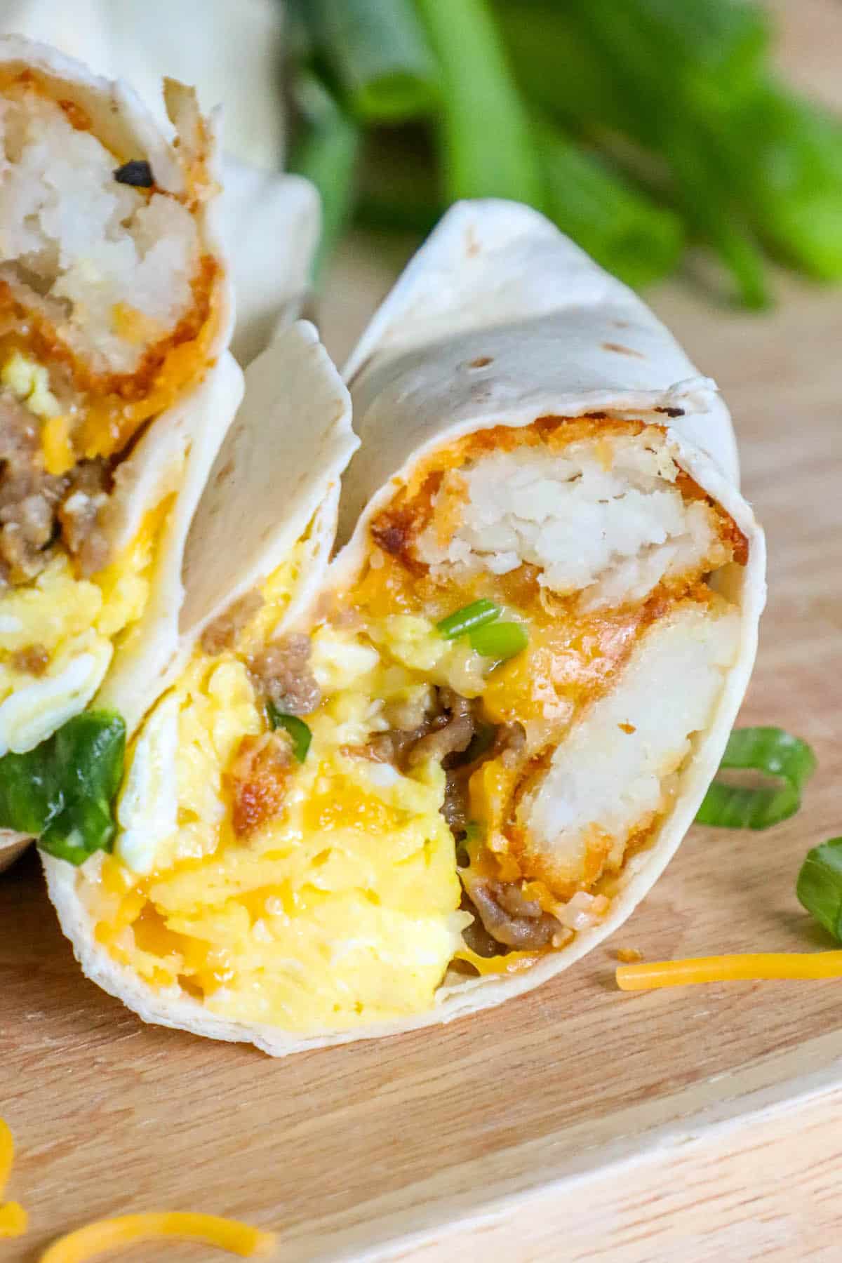 A freezer breakfast burrito with eggs and cheese on a cutting board.