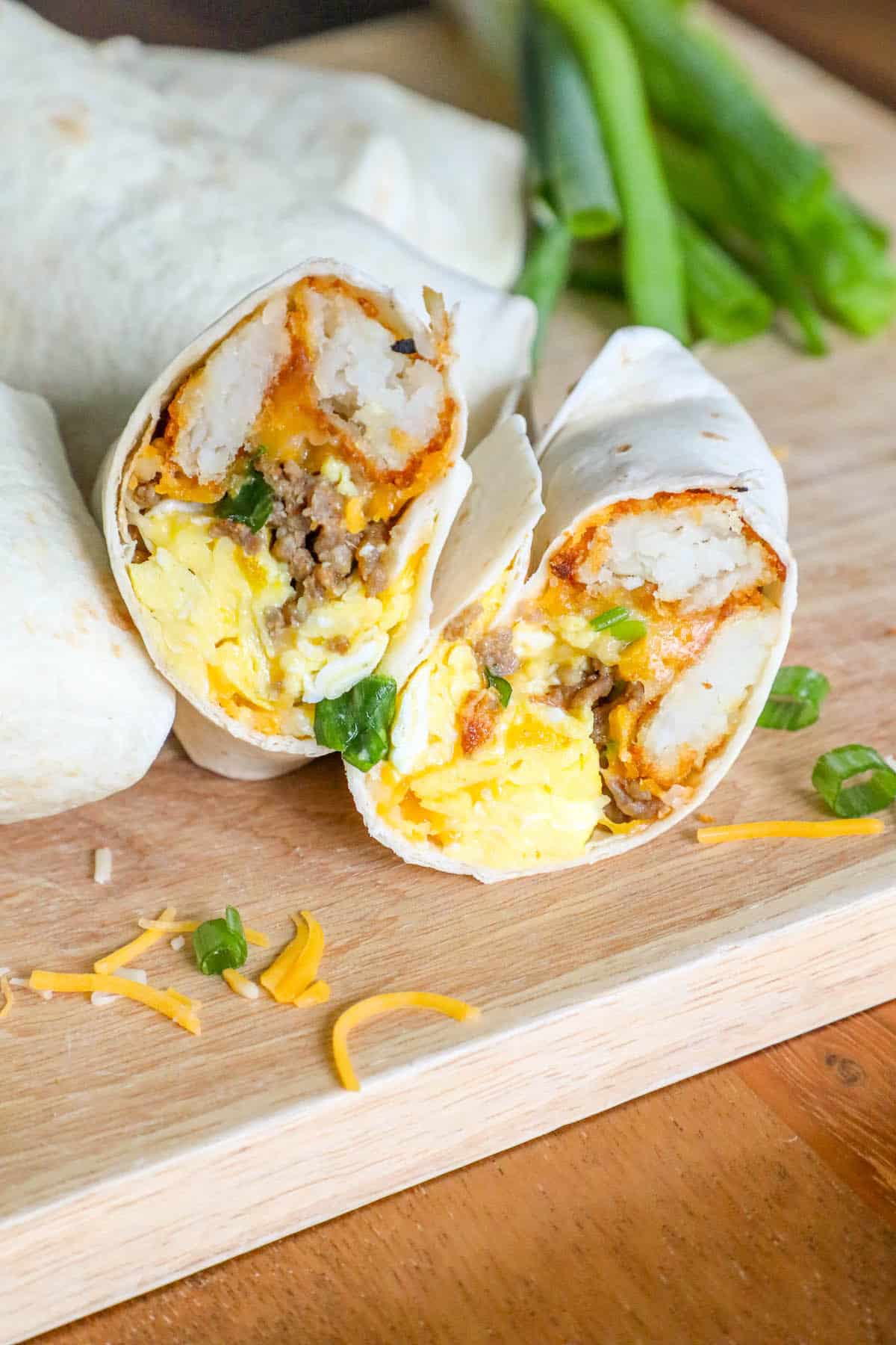 A freezer breakfast burrito with eggs and cheese on a cutting board.