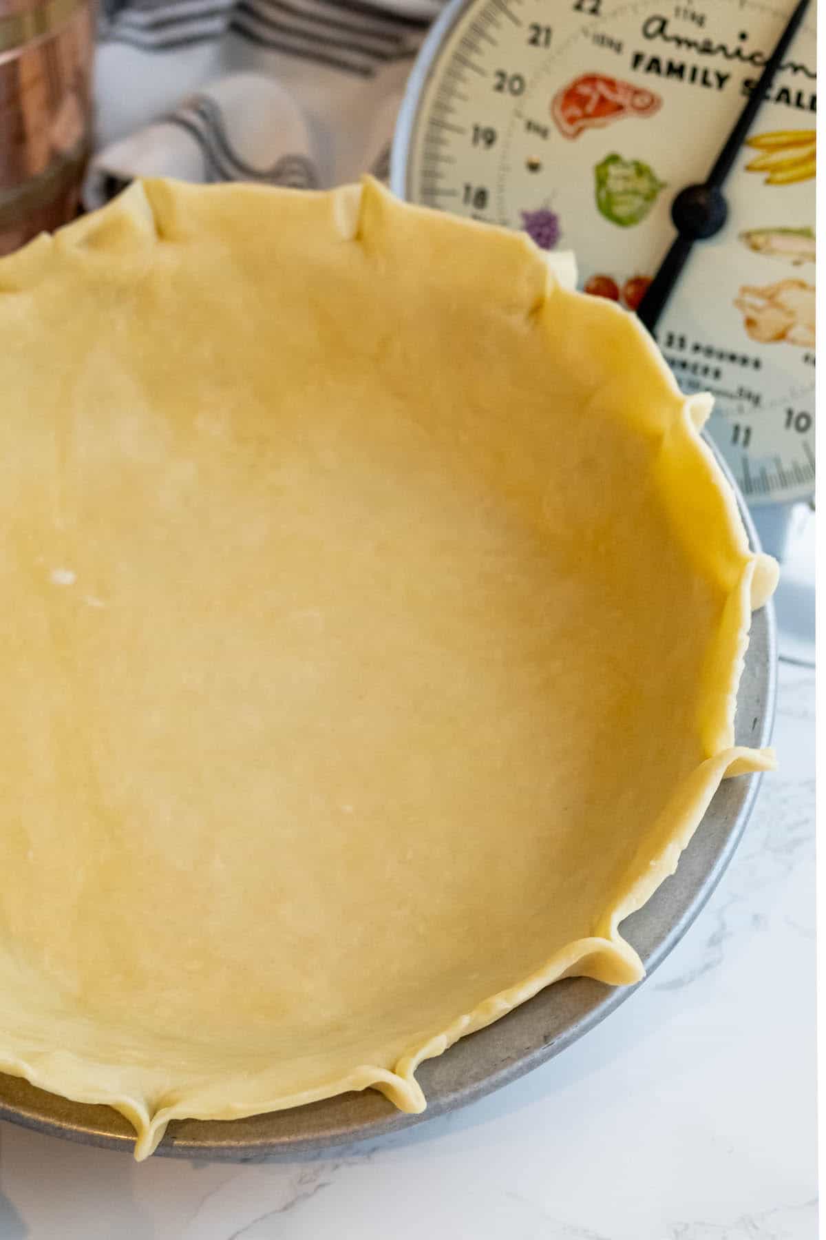 An easy pie crust is being made in a pie pan.