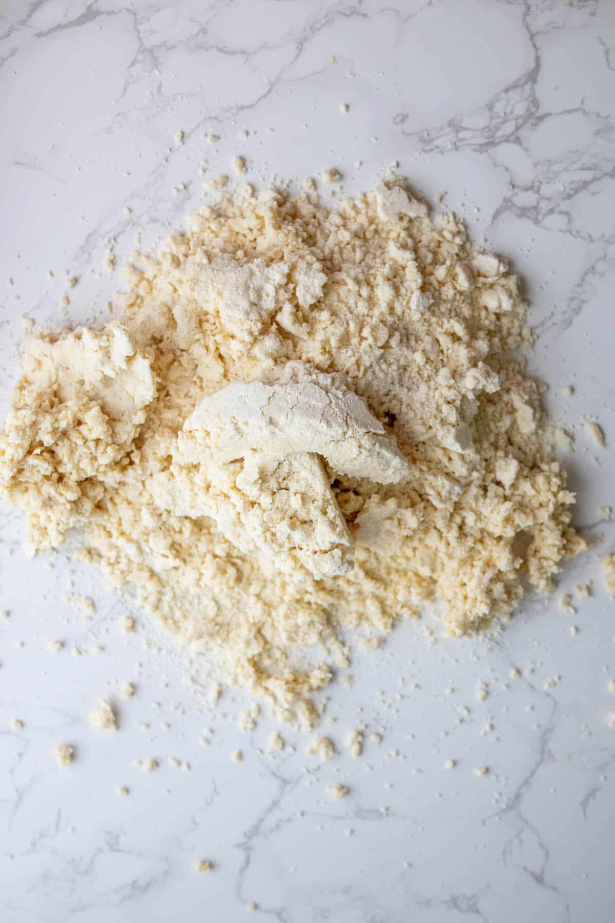 A mound of flour on a marble table for easy pie crust.