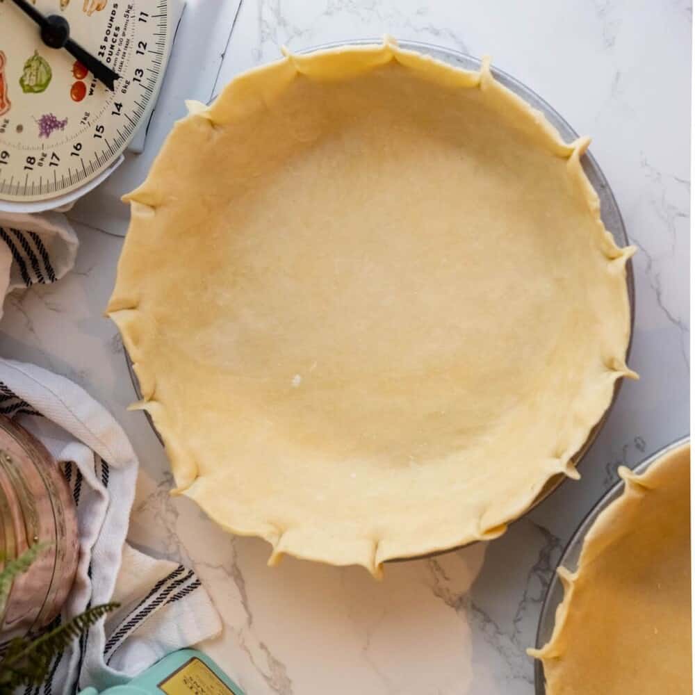 Two easy pie crusts on a marble countertop.