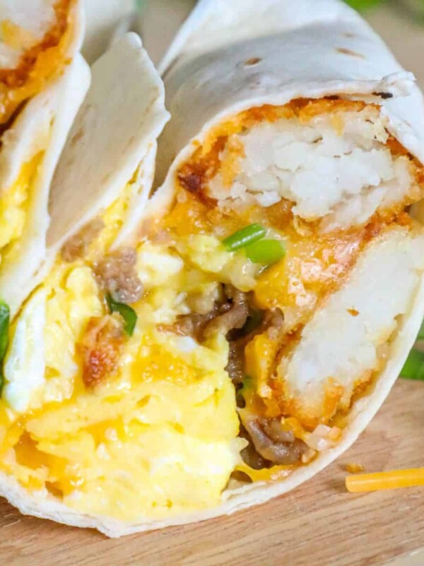 A freezer breakfast burrito with eggs and cheese on a cutting board.