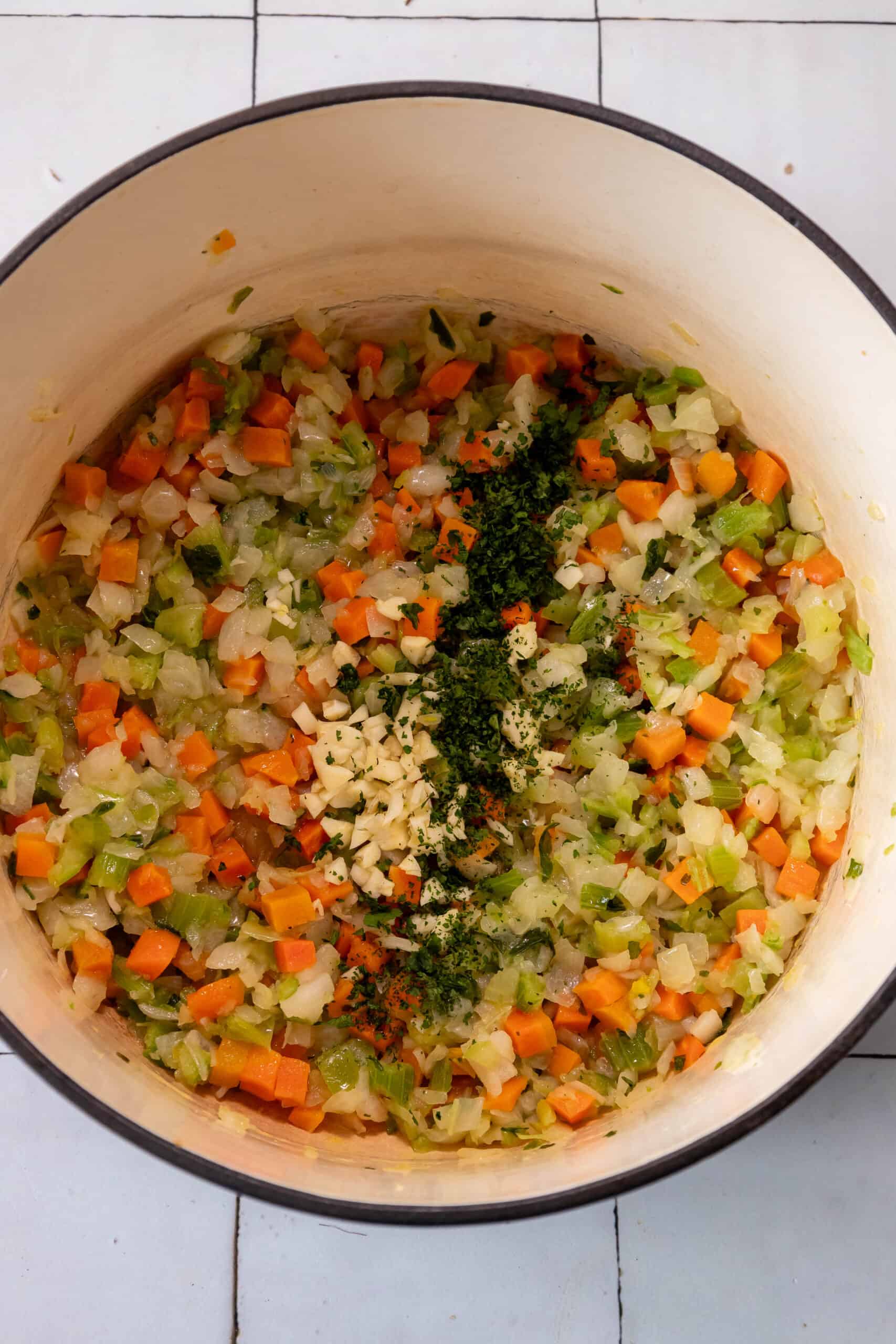 A pot filled with vegetables and herbs.