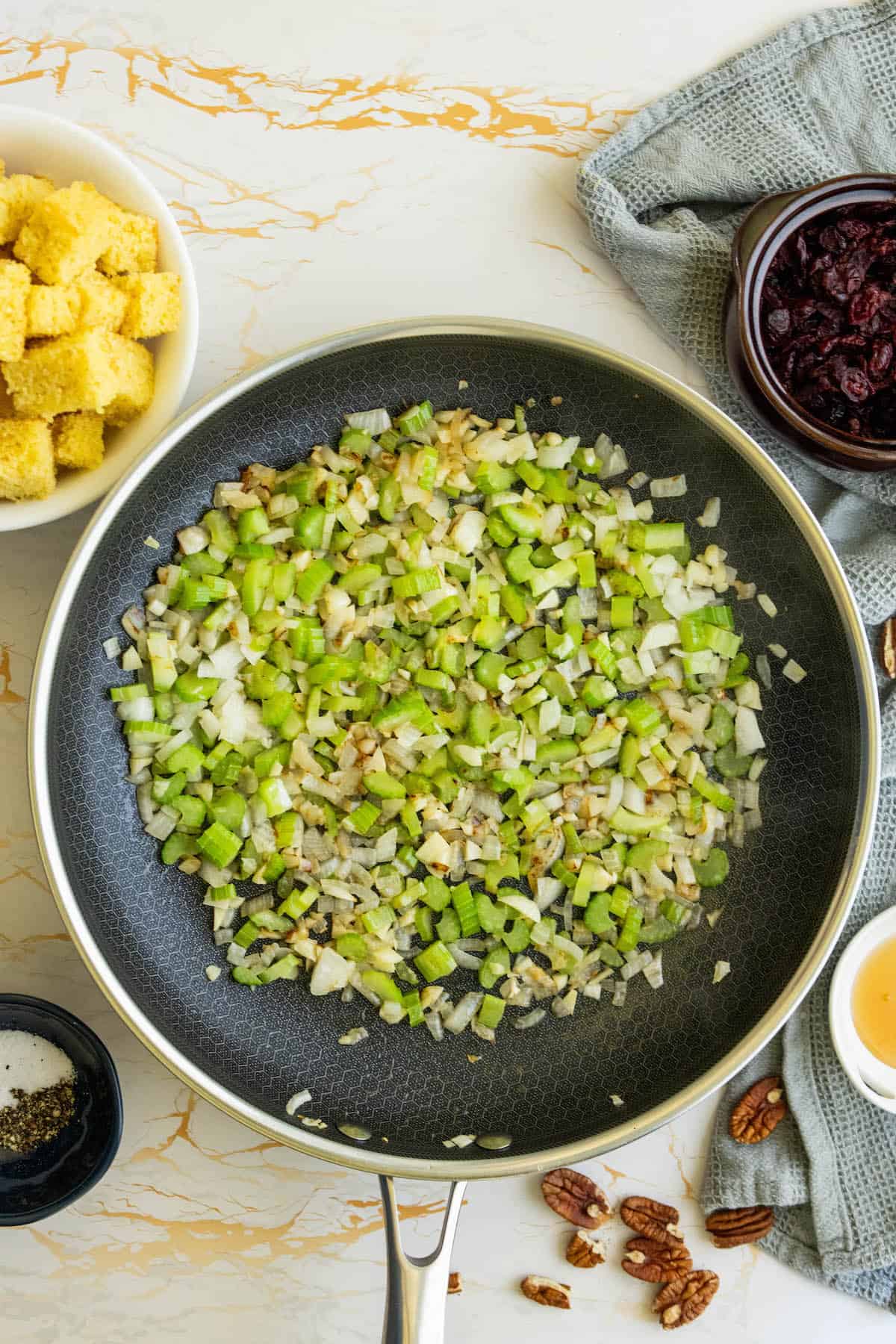 A frying pan with green beans and croutons.