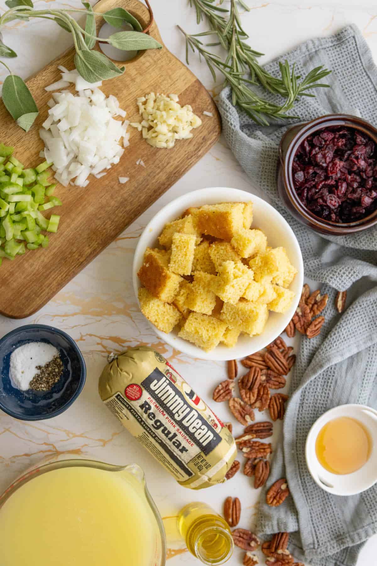 The ingredients for cranberry sausage croutons on a cutting board.