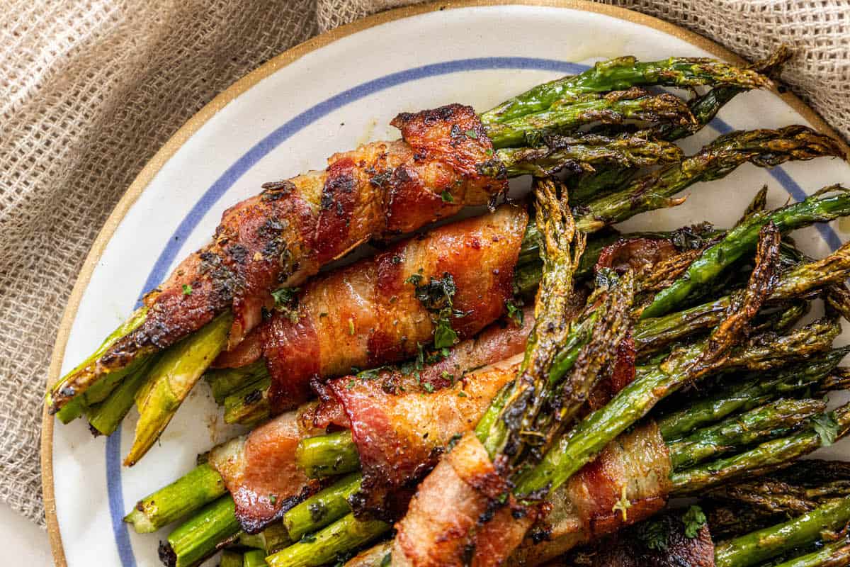 Bacon-wrapped asparagus served on a plate.