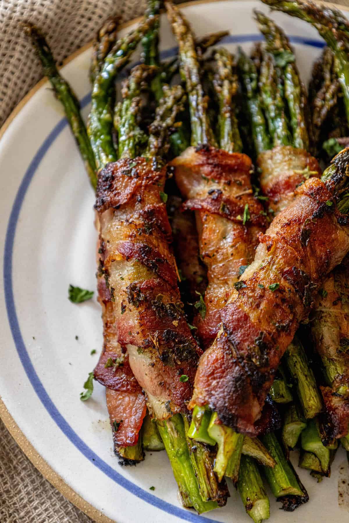 Bacon wrapped asparagus on a plate with garlic-infused flavor.