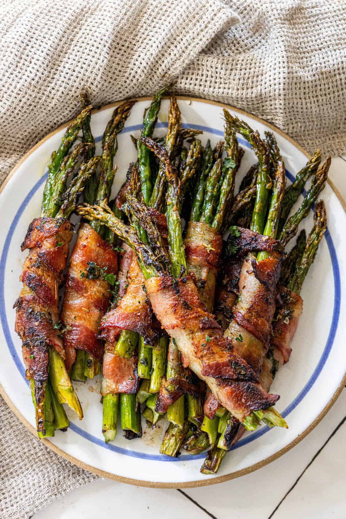 Garlic-infused bacon wrapped asparagus on a plate.