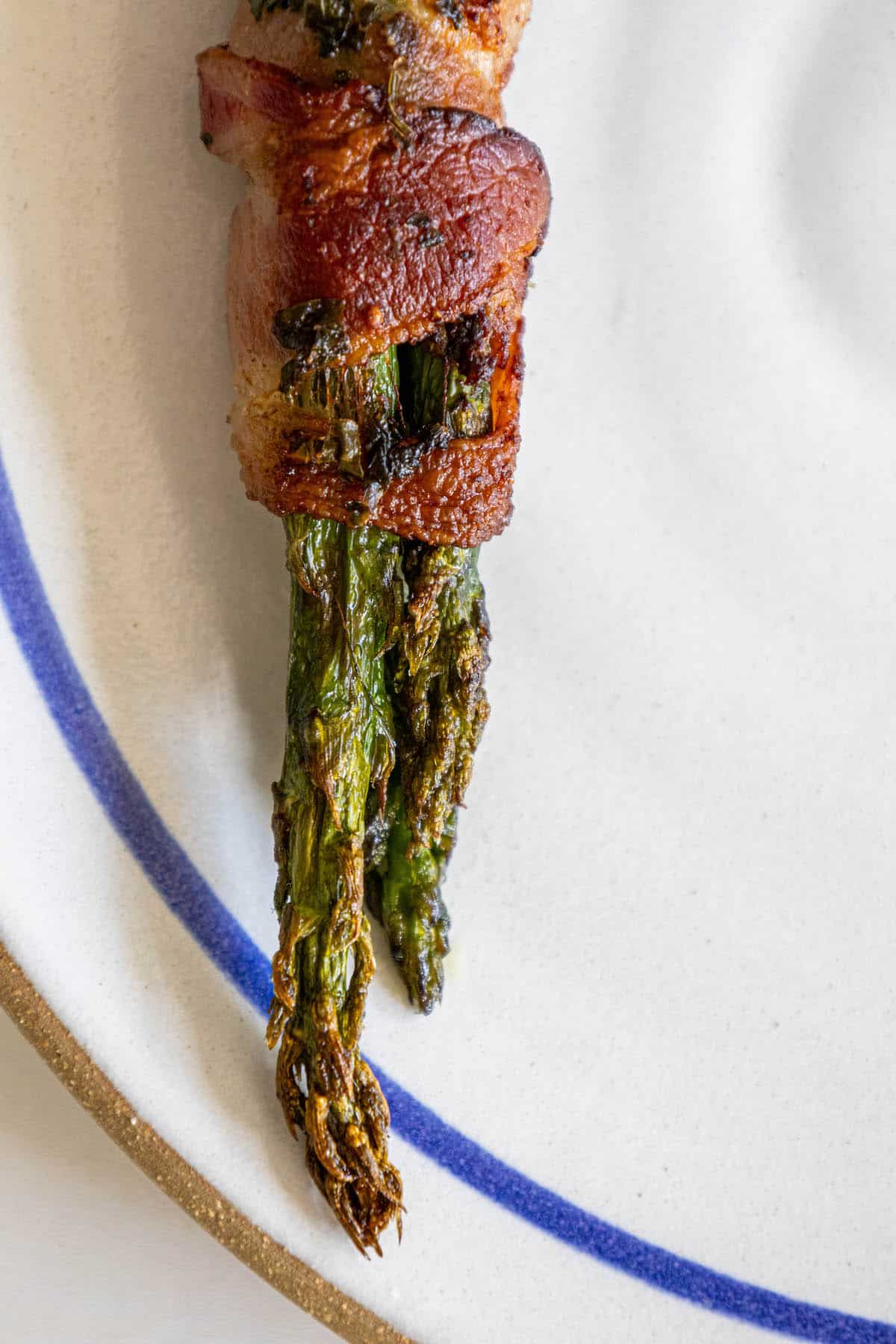 Bacon-wrapped asparagus spears arranged on a plate.