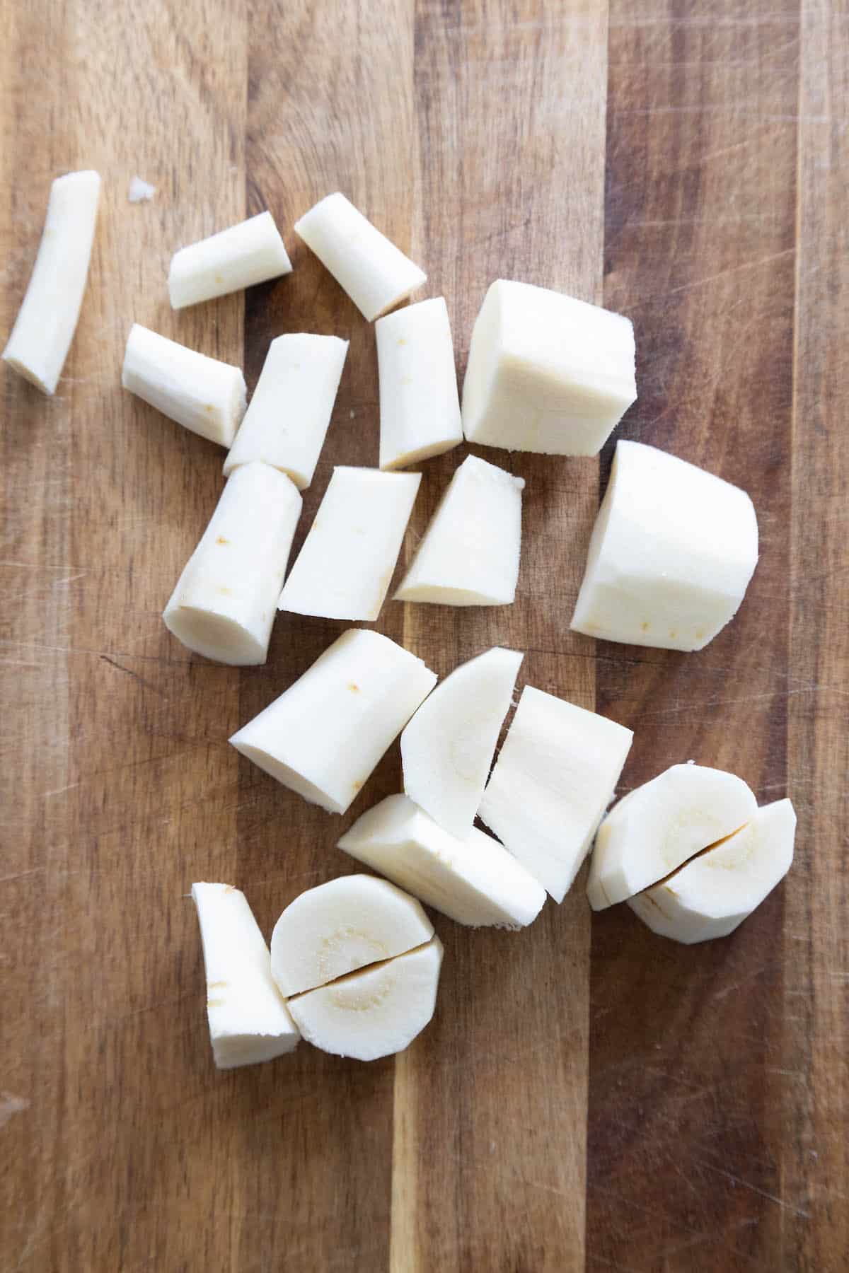 Roasted white potatoes on a wooden cutting board.