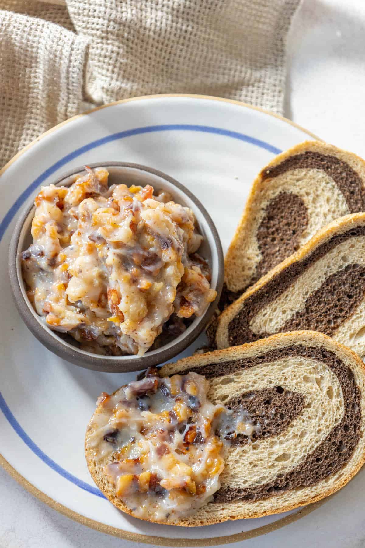A plate with spread bread and a bowl of jam.