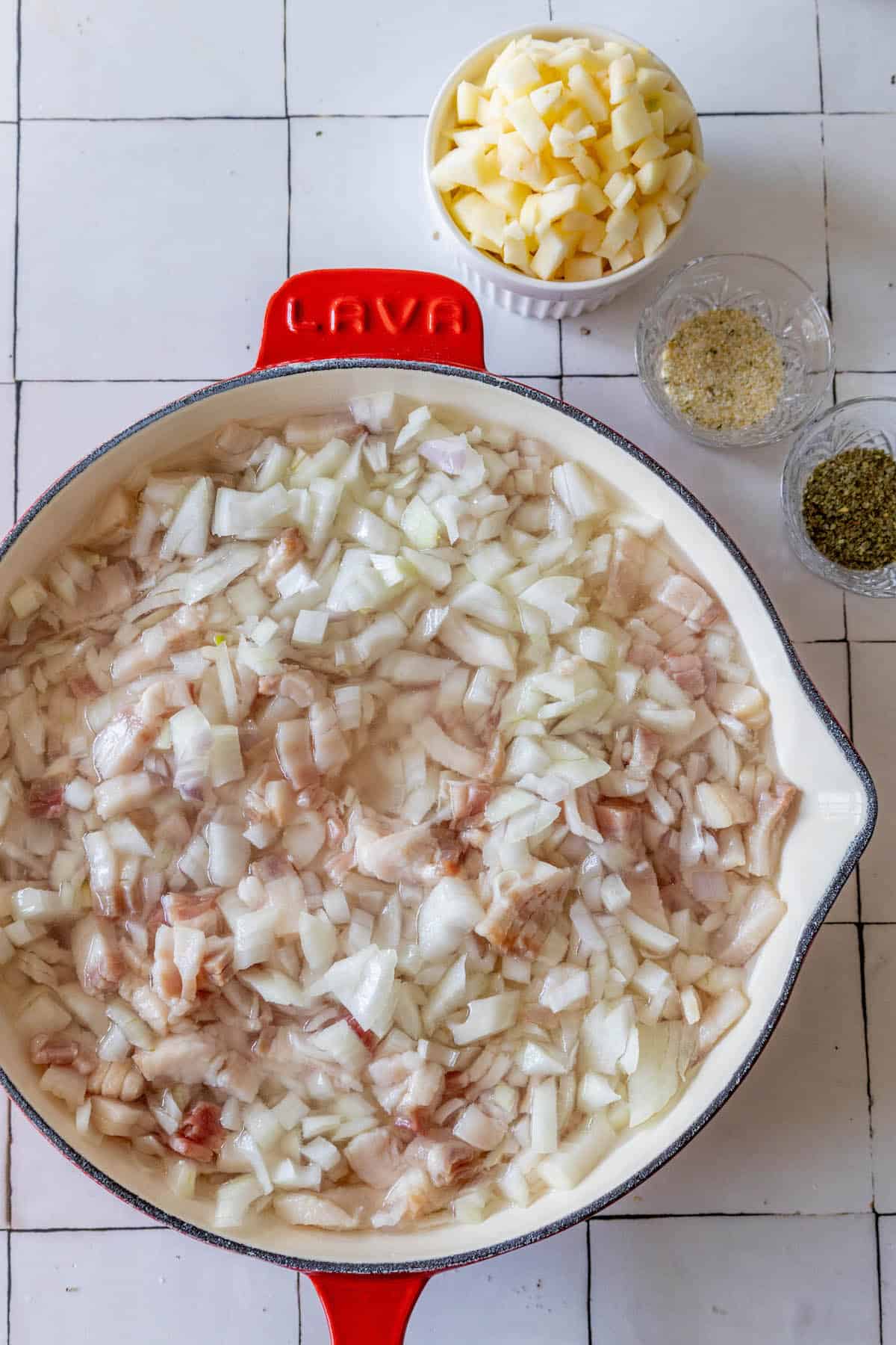A Polish spread of smalec consisting of onions and potatoes on a tiled floor.