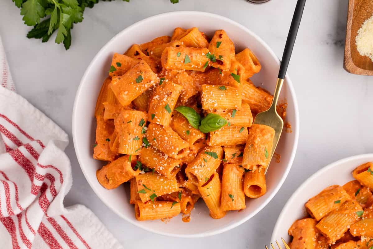 A spicy bowl of rigatoni pasta with sauce and parmesan cheese.