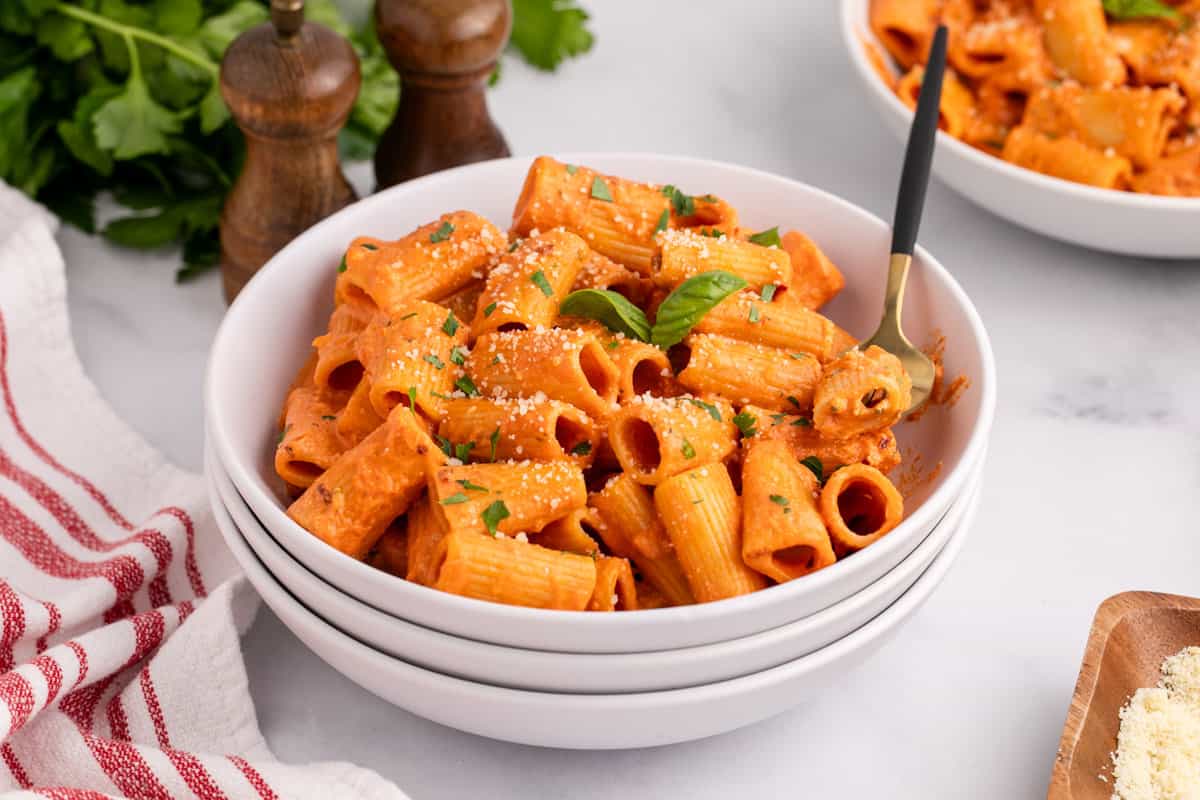A bowl of Spicy Rigatoni Pasta with sauce and parmesan cheese.